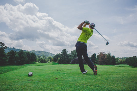 Golfer mid-swing on course